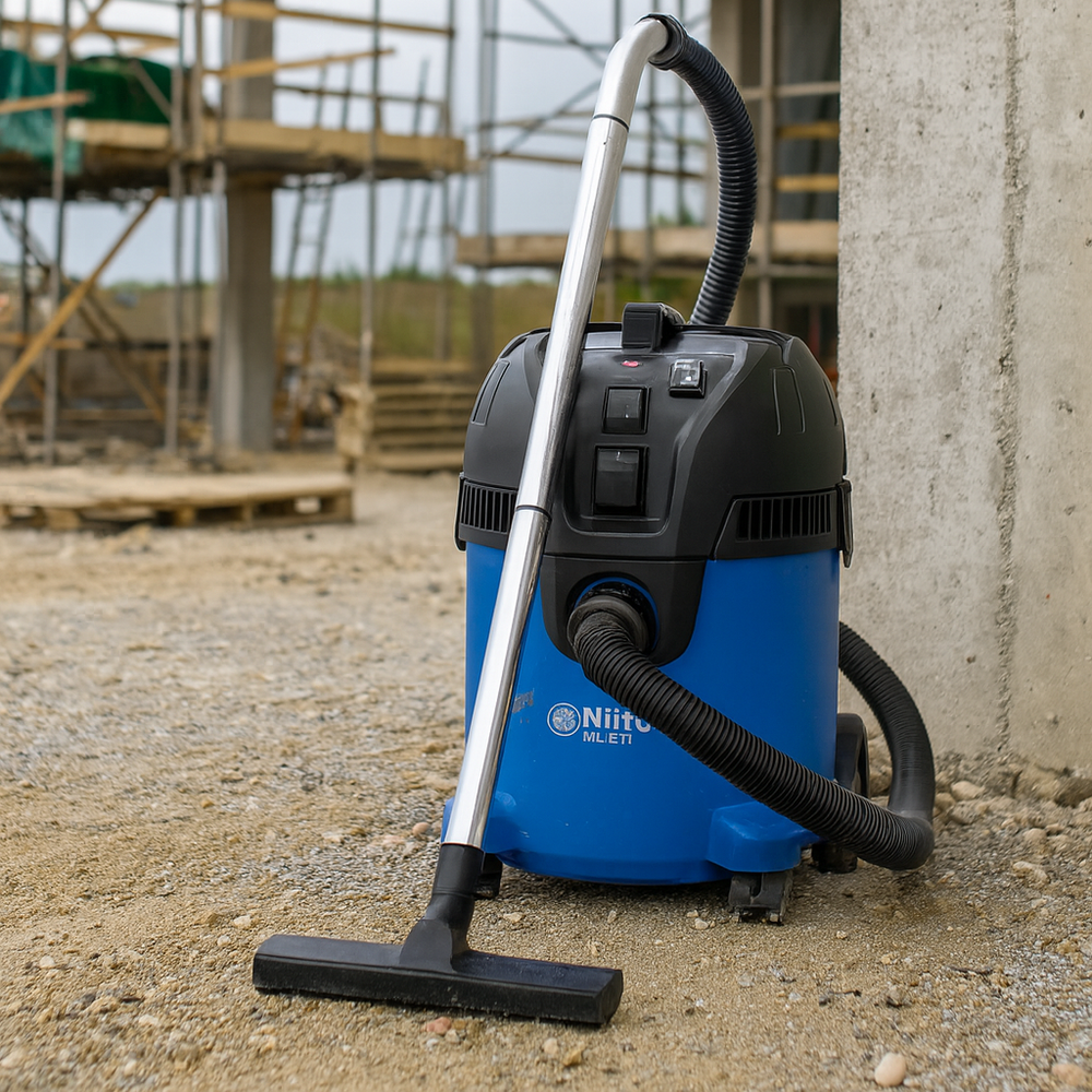 Aspirateur Nilfisk Multi II 22 utilisé sur un chantier, robuste et polyvalent pour gravats, poussières et liquides.